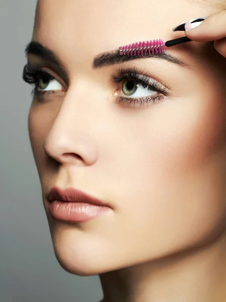 Hermosa joven haciendo maquillaje — Foto de Stock