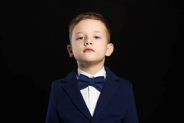 Стильный ребенок в костюме на черном фоне — стоковое фото