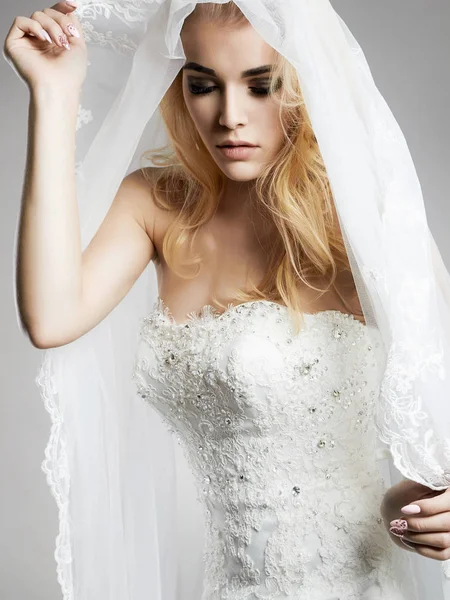 Mulher bonita em vestido de noiva e véu — Fotografia de Stock