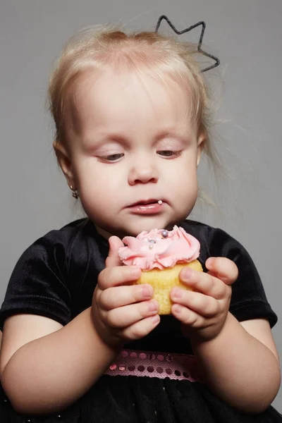 Menina engraçada come um bolo — Fotografia de Stock