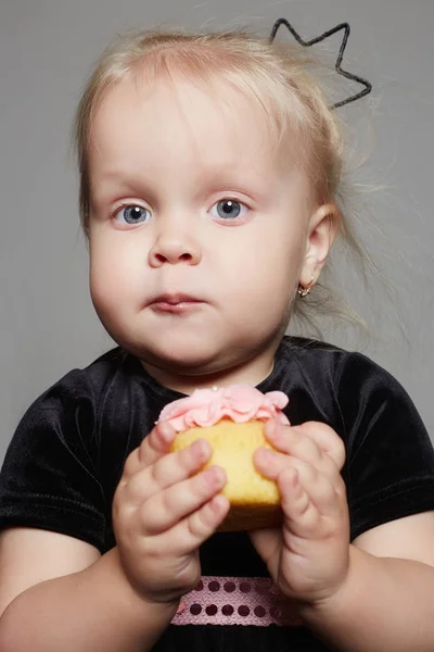 Menina engraçada come um bolo — Fotografia de Stock