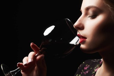 Güzel genç bayan şarap içiyor.
