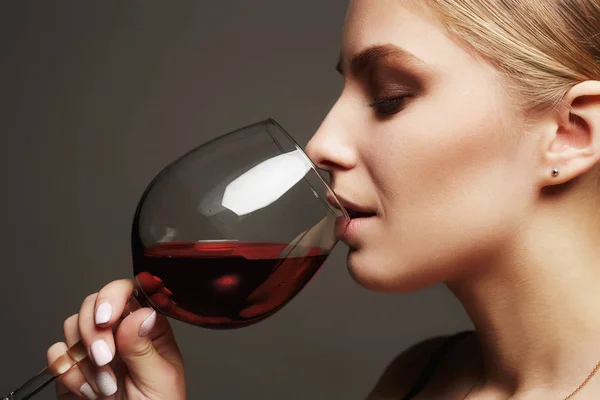 Mulher loira bonita bebendo vinho tinto — Fotografia de Stock