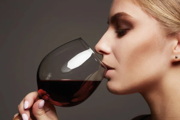 Bella giovane donna che beve vino rosso — Foto Stock