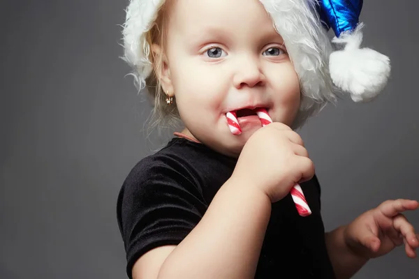 Śmieszne santa dziewczynka. szczęśliwe dziecko z lollipop candy — Zdjęcie stockowe