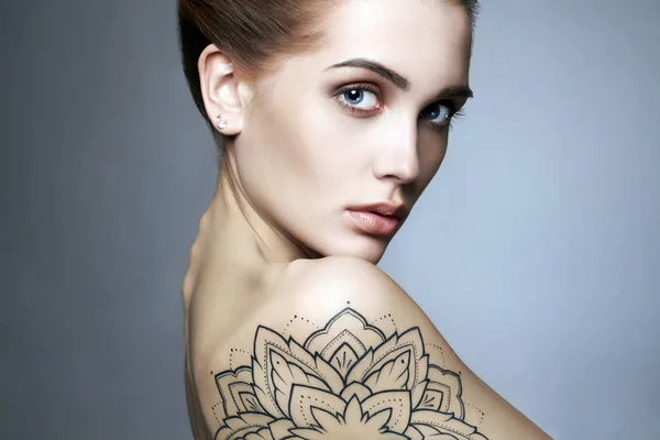 Jeune femme blonde avec tatouage — Photo