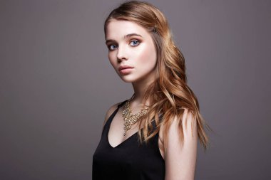 Güzel, şehvetli, sarışın, siyah elbiseli, mücevherli kız.