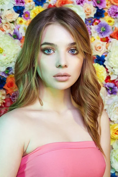 Όμορφη νεαρή γυναίκα πάνω από τα λουλούδια χρώμα — Φωτογραφία Αρχείου