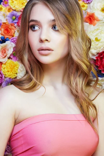 Hermosa mujer joven sobre flores de color —  Fotos de Stock