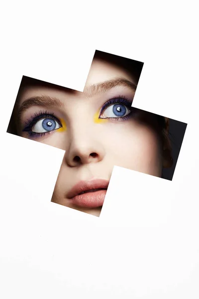 Ženský obličej s barevným make-upem do papírové díry — Stock fotografie