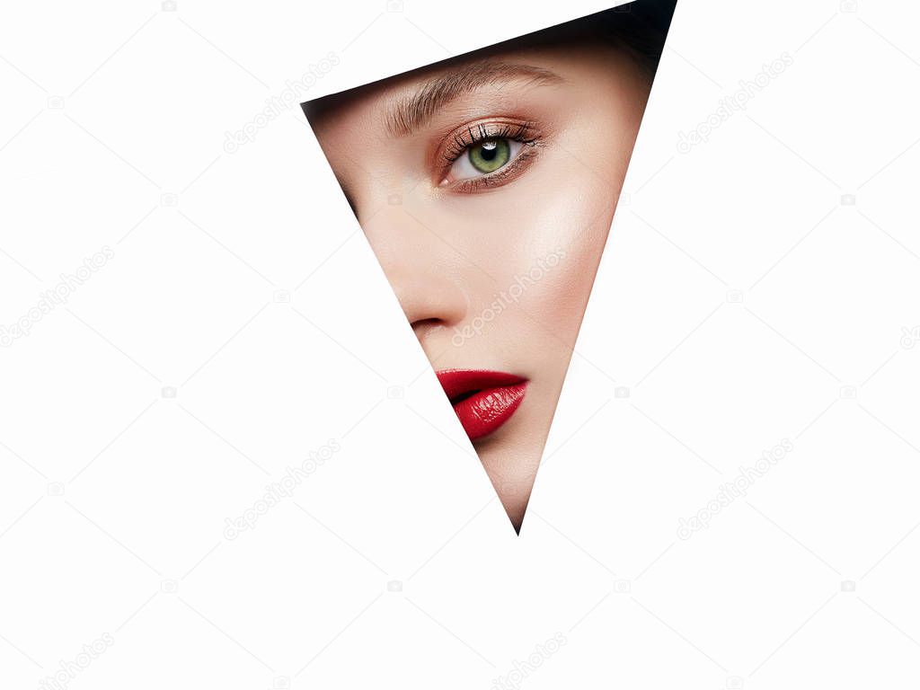 female face into paper hole. make-up artist concept