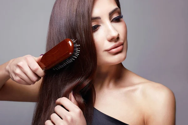 Beautiful girl combing her hair. Beautiful Hair care — Stock Photo, Image