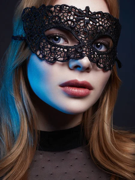 Bella giovane donna in maschera. Luci di colore — Foto Stock