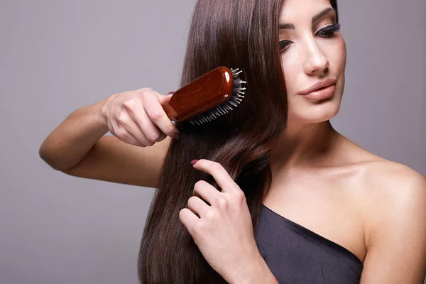 Menina bonita com escova de cabelo. Belo cuidado do cabelo — Fotografia de Stock