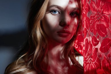 Şehvetli, güzel, kırmızı perdeli bir kadın.