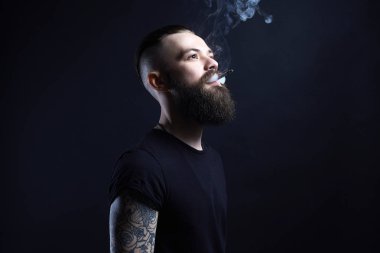 yakışıklı sakallı sigara adam. Hipster tattoed çocuk ile sigara