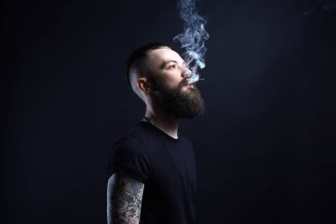 yakışıklı sakallı sigara adam. Hipster tattoed çocuk ile sigara