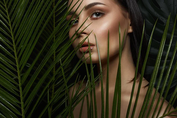 wild woman in Jungle. beautiful girl in palms. Beautiful tanned woman with Make-up. Beauty Portrait