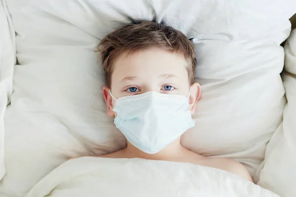 마스크쓴 전염병같은 Covid 침대에 있는아이 의료용 마스크를 — 스톡 사진