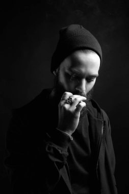 Şapkalı yakışıklı, sakallı, sigara içen adam. Sigaralı hippi çocuk.