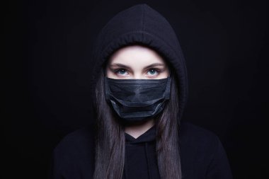 Maskeli ve Başlıklı Genç Kadın. Siyah maskeli ve kapüşonlu kız. Coronavirüs salgını