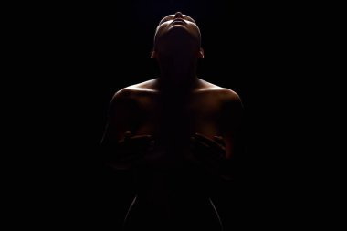 Karanlıkta ışığın altında çıplak kadın silueti. Güzel Çıplak Vücut Kızı