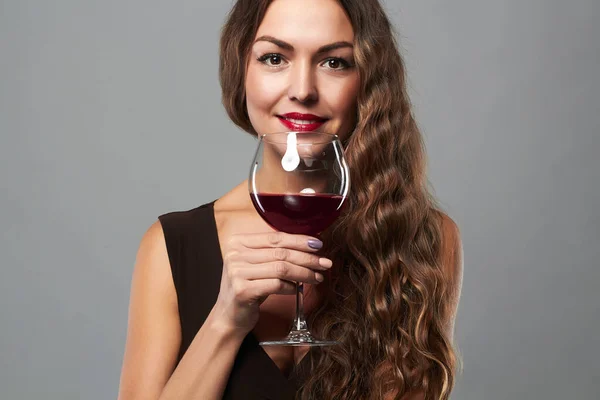 happy smiling woman with glass of wine.Beautiful middle aged woman with curly hair style drinking red wine