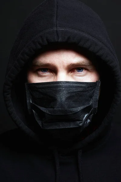 Man in Mask and Hood. Boy in Black Mask and Hoodie. Coronavirus epidemic. Covid-19