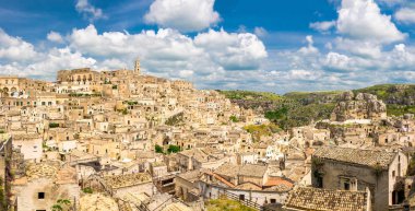 Tarihi şehir Sassi di Matera 'nın havadan panoramik manzarası kaya mağarası evleri, mavi gökyüzü beyaz bulutları, Unesco Dünya Mirası Alanı, Basilicata, Güney İtalya