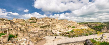 Tarihi şehir Sassi di Matera 'nın havadan panoramik manzarası kaya mağarası evleri, mavi gökyüzü beyaz bulutları, Unesco Dünya Mirası Alanı, Basilicata, Güney İtalya