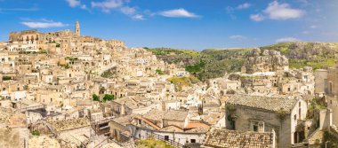Tarihi şehir Sassi di Matera 'nın havadan panoramik manzarası kaya mağarası evleri, mavi gökyüzü beyaz bulutları, Unesco Dünya Mirası Alanı, Basilicata, Güney İtalya