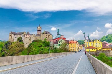 Madalyon Şatosu Hrad Loketi Gotik tarzı binalar büyük kayalar üzerinde, renkli binalar kasabada, köprü eğer nehri üzerinde, mavi bulutlu gökyüzü arka planı, Karlovy Vary Bölgesi, Batı Bohemya, Çek Cumhuriyeti