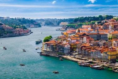 Portugal, Porto in June, Douro river, panoramic view of old town, tourist centre of Porto, unusual magic sunny Porto, light white clouds over Porto, colorful houses with red roofs in Porto