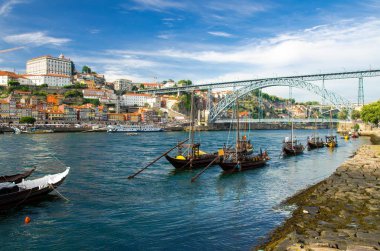 Portugal, city landscape Porto, wooden boats with wine port barrels on Douro river, panoramic view of the old town Porto,  The Eiffel Bridge view, Ponte Dom Luis, Porto in summer, colored houses