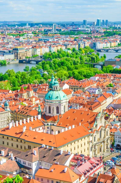 Top aerial vertical view of Prague historical city centre with red tiled roof buildings in Mala Strana Lesser Town, Church of Saint Nicholas, bridges over Vltava river, Bohemia, Czech Republic