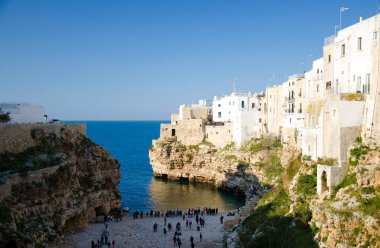 Güney İtalya 'nın Puglia Apulia bölgesinde bir kısrak, Polignano kasabasında mağaralar ve kayalıklarda bulunan Lama monachile cala porto ve beyaz binaların manzarası
