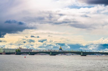 Saint Petersburg (Leningrad) şehrinin Neva nehri boyunca uzanan Trinity köprüsü (bascule köprüsü) ve Saint Isaac Katedrali 'nin altın kubbesi, mavi bulutlu gökyüzü, Rusya