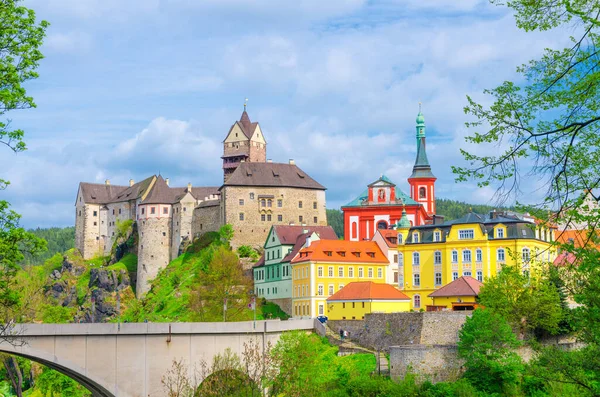 Madalyon Şatosu Hrad Loketi Gotik tarzı binalar büyük kayalar üzerinde, renkli binalar kasabada, köprü eğer nehri üzerinde, mavi bulutlu gökyüzü arka planı, Karlovy Vary Bölgesi, Batı Bohemya, Çek Cumhuriyeti