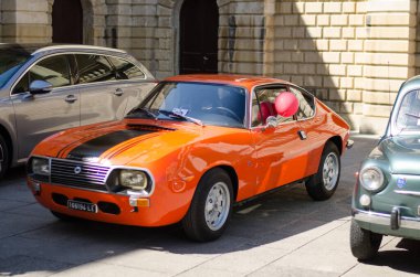 Lecce, İtalya - 23 Nisan 2016: Güney İtalya 'nın Puglia Apulia bölgesinde Lecce şehrinin bir caddesinde park edilmiş klasik klasik turuncu otomobilin ön sağ tarafı