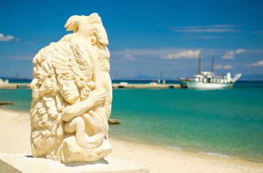 Pefkohori, Yunanistan - 17 Mayıs 2016: Makedonya 'nın Halkidiki kenti yakınlarındaki Toroneos Kolpos körfezinin mavi cennet suyunda heykel heykeli ve teknesi