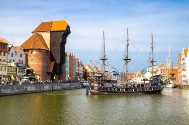 Gdansk, Polonya, 15 Nisan 2018: Motlawa nehir suyu üzerinde ortaçağ ahşap gemisi, tipik renkli evler binalar ve tarihi kent limanındaki Long Bridge seti gezinme güvertesi caddesinde Zuraw Crane