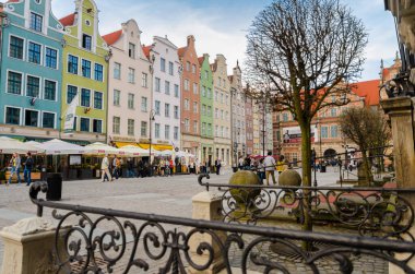 Gdansk, Polonya, 15 Nisan 2018: Dluga Long Market Caddesi Dlugi targ Meydanı 'ndaki güzel, tipik renkli binalar, Brama Zielona Yeşil Kapısı ve ağaçların cephesi