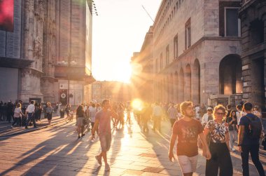 Milano, İtalya, 8 Eylül 2018: Gençler Corso Vittorio Emanuele II caddesinde yürüyorlar Duomo di Milano katedrali yakınlarında, Piazza del Duomo Meydanı şehir merkezinde güneşe karşı