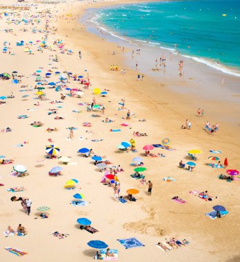 Portimao, Algarve, Portekiz, 19 Haziran 2017: Praia de Rocha plajı turistler ve renkli şemsiyelerle
