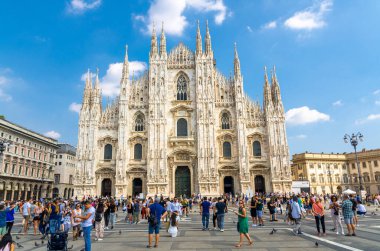 Milan, İtalya, 9 Eylül 2018: Duomo di Milano Katedrali 'nde, açık güneşli bir günde mavi gökyüzü arka planıyla tarihi şehir merkezinde Piazza del Duomo meydanında yürüyen insanlar var.