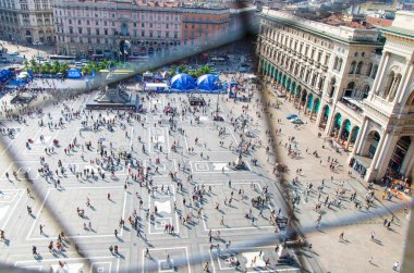 Milan, İtalya, 9 Eylül 2018: Duomo di Milano katedralinin üst manzarası olan tarihi merkez Vittorio Emanuele II Galerisi yakınlarındaki Piazza del Duomo meydanında küçük insan figürleri yürüyor