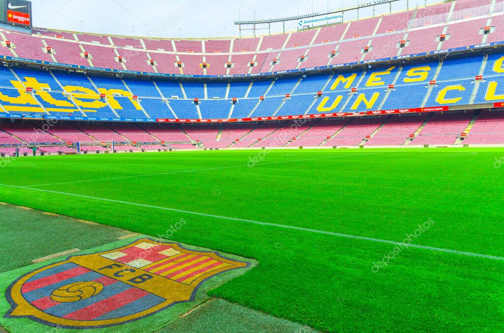 Barcelona, Spain, March 14, 2019: Camp Nou is the home stadium of football club Barcelona, the largest stadium in Spain. View of tribunes stands, green grass field and logo from reserves bench.