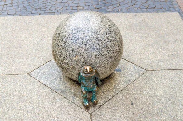 Wroclaw, Polen, 7 mei 2019: Dwerg duwt marmeren bal, beroemde bronzen miniatuur kabouter — Stockfoto