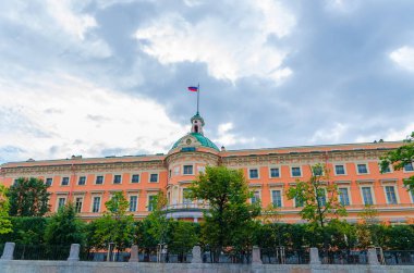 Üzerinde Rus bayrağı olan Mikhailovsky Kalesi, mavi dramatik gökyüzü arka planı, Saint Petersburg
