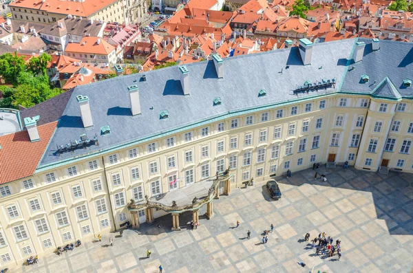 Vista superior de la plaza del patio del Castillo de Praga y el Antiguo Palacio Real con pequeñas figuras de personas caminando — Foto de Stock